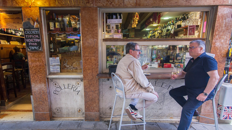 Venetians outside a bacaro eating Italian tapas with wine.