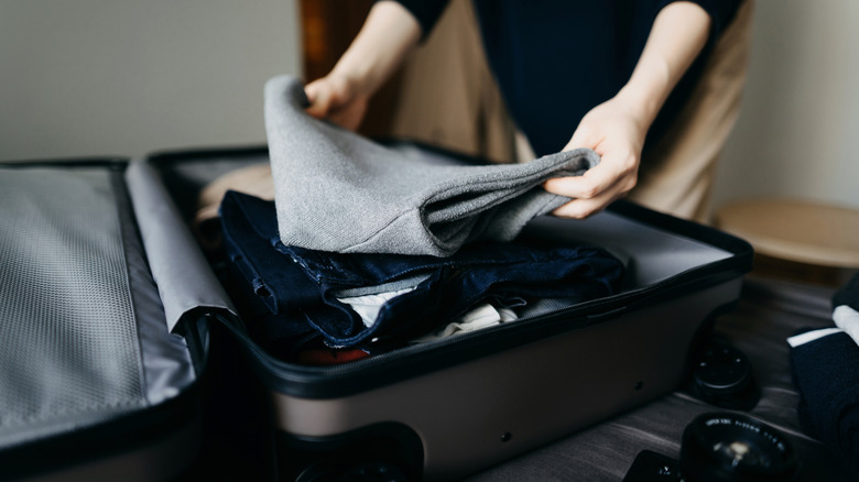 person packing a suitcase