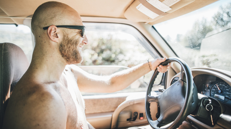 Man driving without shirt