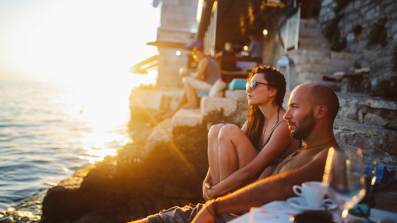 Travelers sitting in cliffside cafe