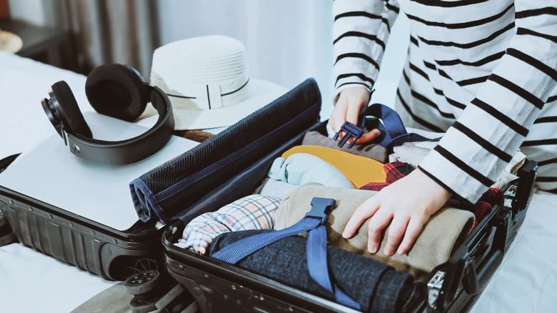 Person packing a suitcase