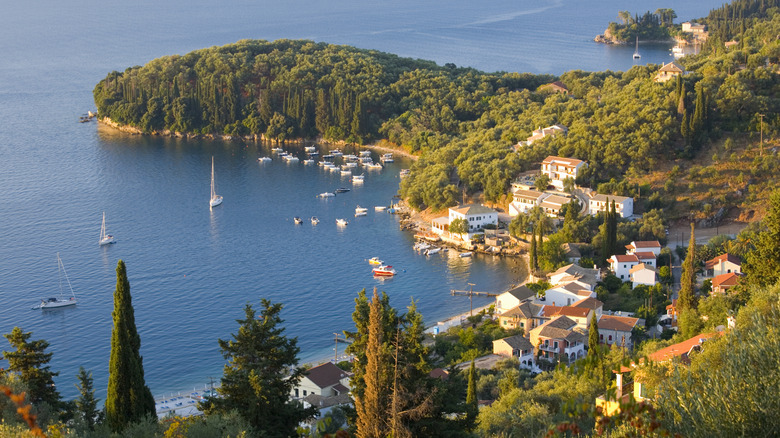 Panorama of a colorful village in forested bay in Greece