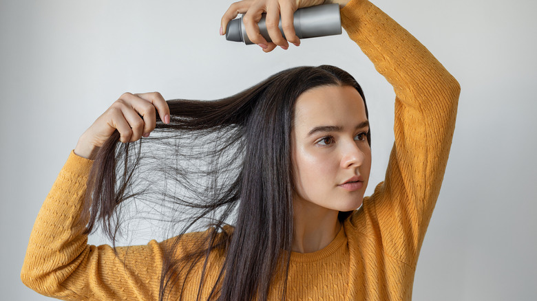 Girl applying hair spray