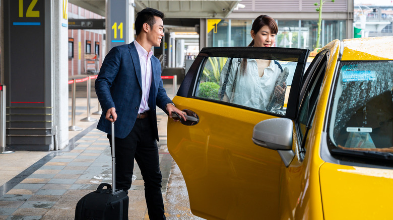 couple getting into airport taxi