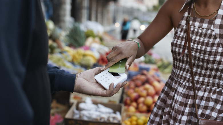 Person paying with contactless card at an outdoor market