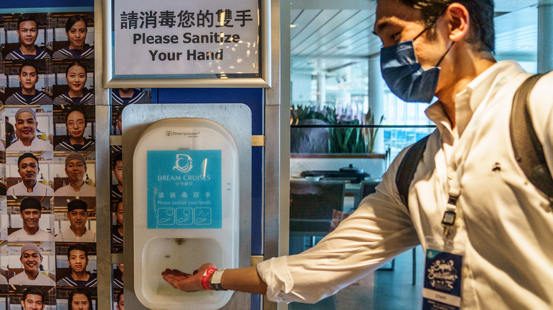 Man uses a hand sanitizer machine 