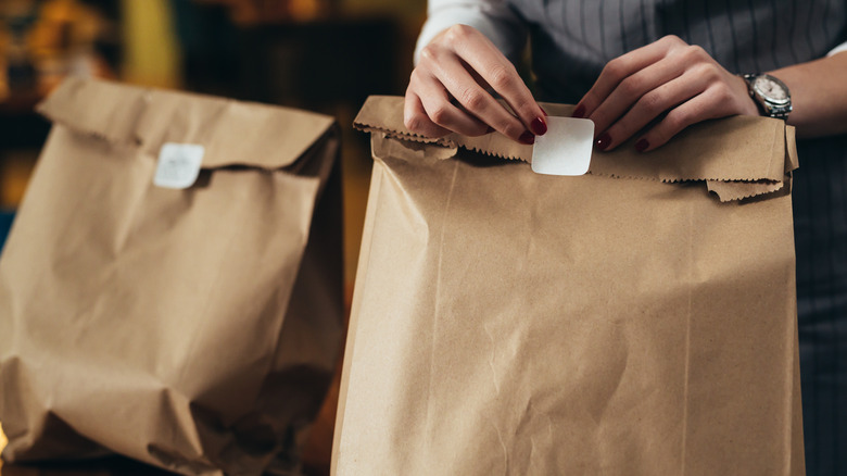 person packing restaurant take-out bag