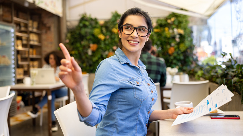 Traveler raising hand to call a waiter