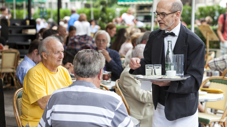 Waiter serving two customers