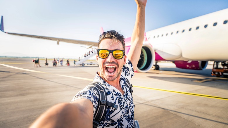 man taking selfie by airplane