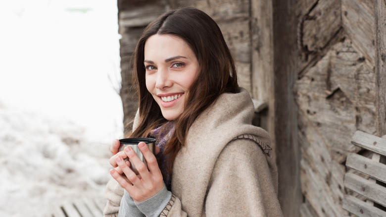 woman sipping hot drink on the mountain