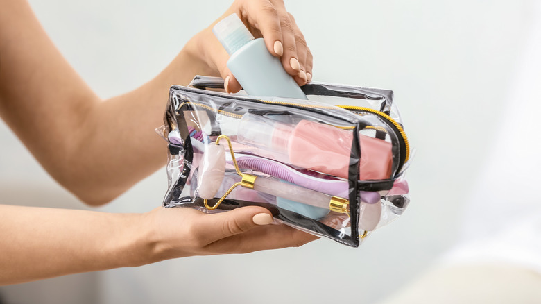 Woman packing toiletry bag.