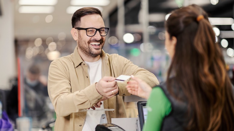 happy man paying with credit card