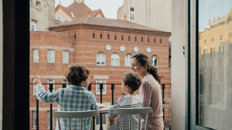 Family on balcony overlooking a historic city