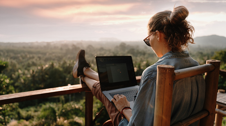 woman on laptop outdoors in hotel