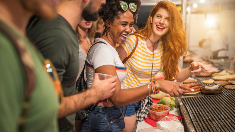 Group of travelers ordering street food