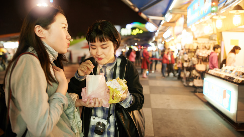 Two travelers sharing street food