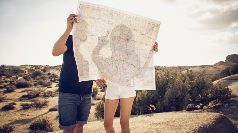 couple stares at a map on a hike outside