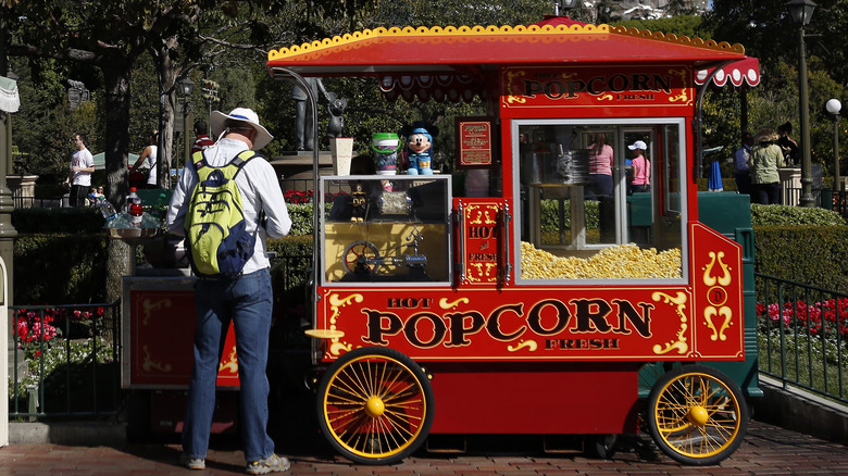 Man purchasing popcorn at popcorn cart