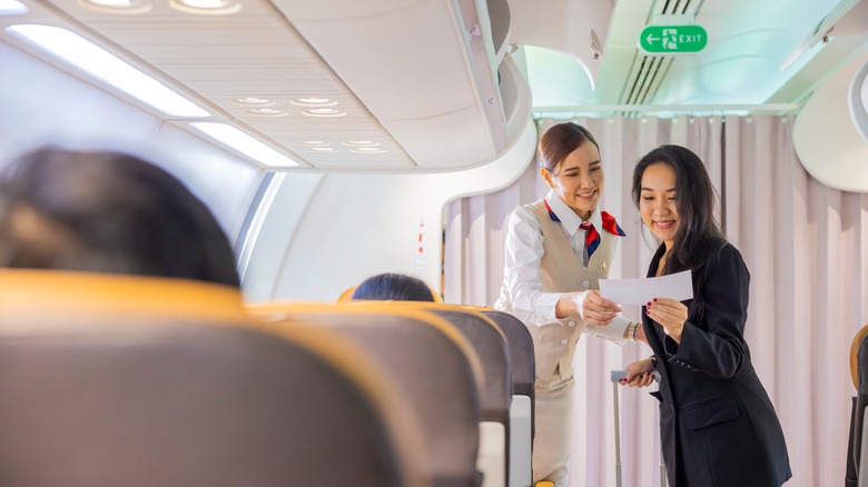 passenger showing ticket to flight attendant
