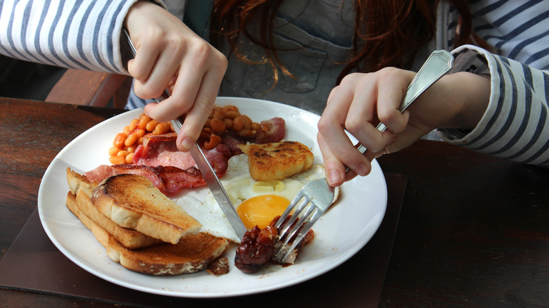 Person eating a full English breakfast