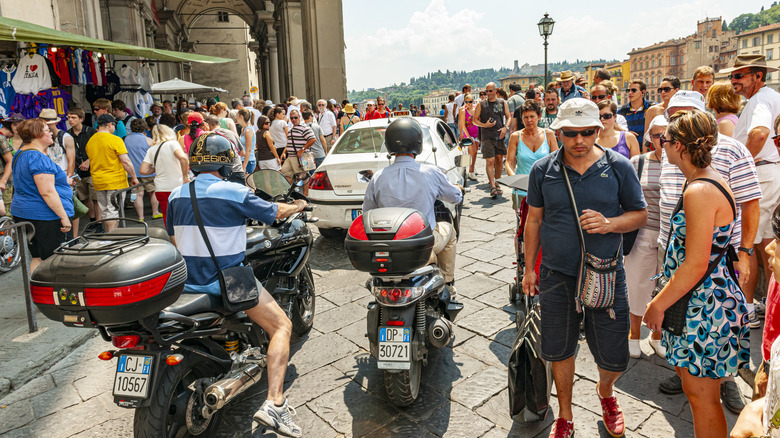 men on scooters through crowds