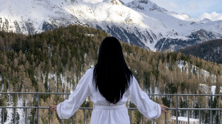 Woman looking at the swiss alps from hotel balcony