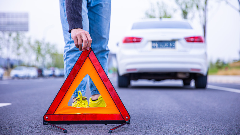 person setting up emergency triangle