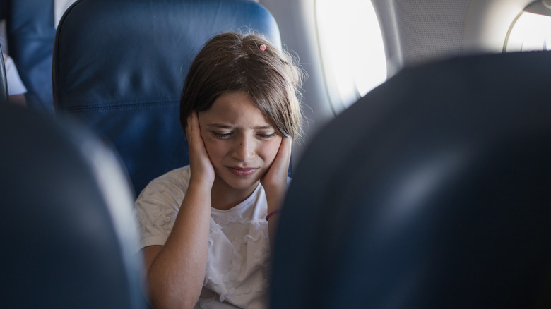 Child having earache on plane
