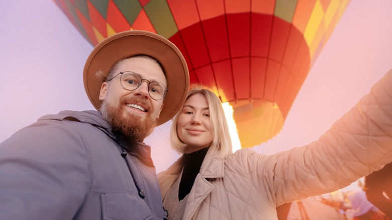 Travel couple in front of a hot-air balloon