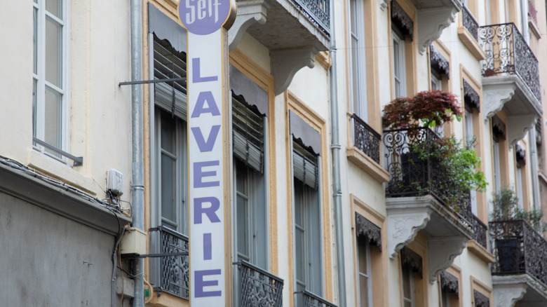 A vertical sign advertises a French laundry service