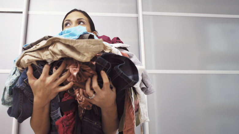 Woman holds a pile of laundry in her hands