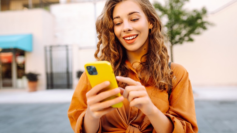 Smiling traveler texting