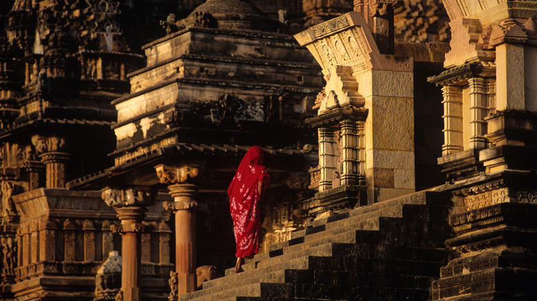 Visitor climbs steps of Khajuraho temple