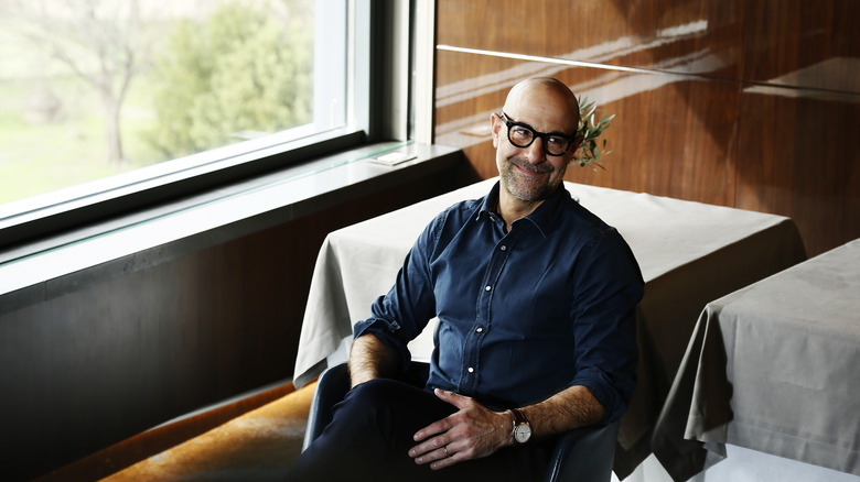 actor Stanley Tucci sitting at a table