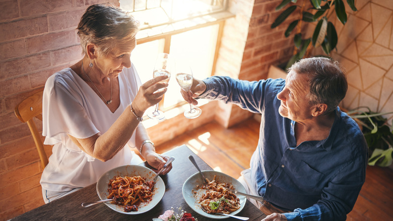 Older couple toasts during meal