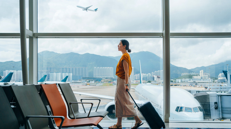 A woman drags her suitcase through the airport.