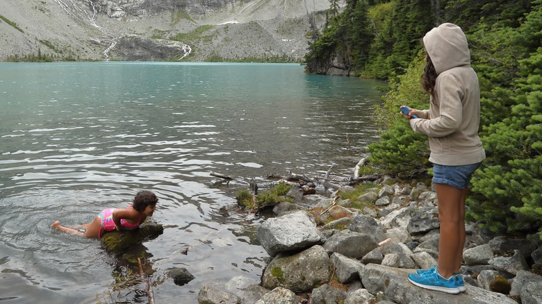 Person watching swimmer in lake