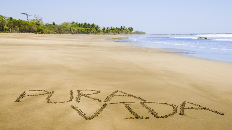 pura vida written in sand