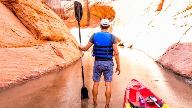 kayaker standing in canyon waterway