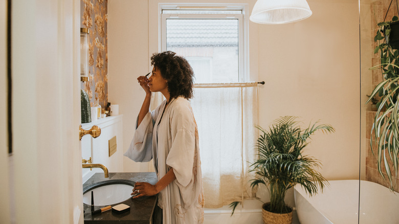 Traveler applying makeup in the bathroom