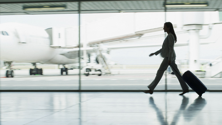 Woman pulling suitcase at airport