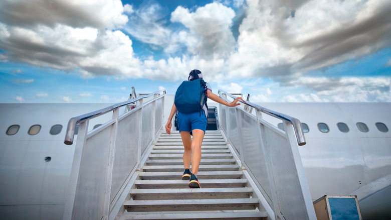 A passenger walks up plane steps.