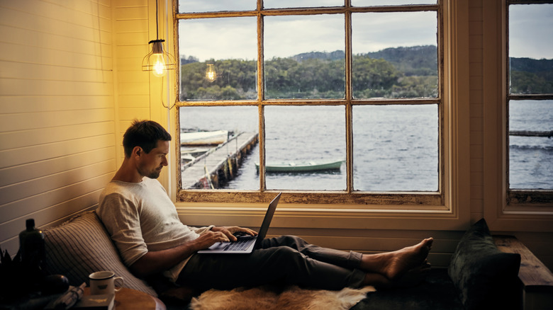 Traveler using laptop by the window