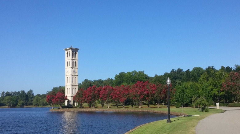 a lake in front of a bell tower