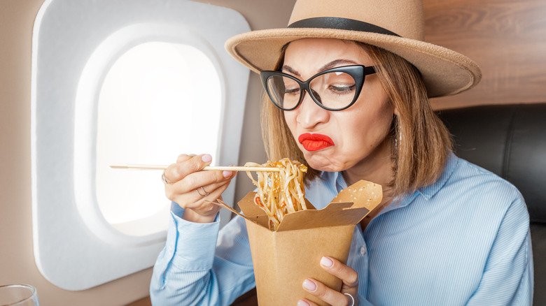 woman unhappily eating pasta