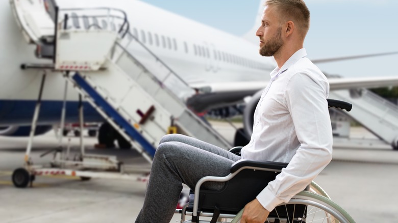 man in wheelchair outside plane