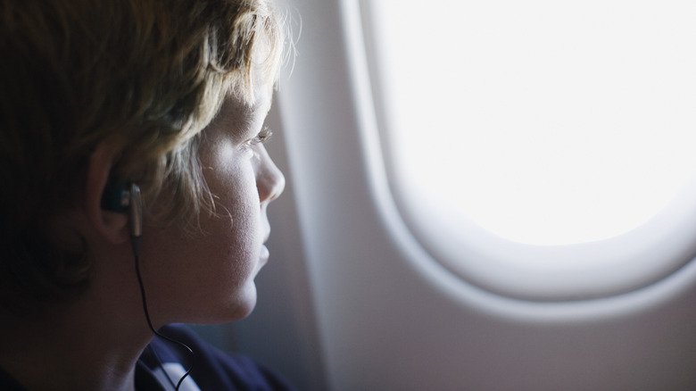 boy looking out airplane window