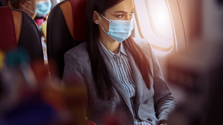 woman wearing mask in airplane