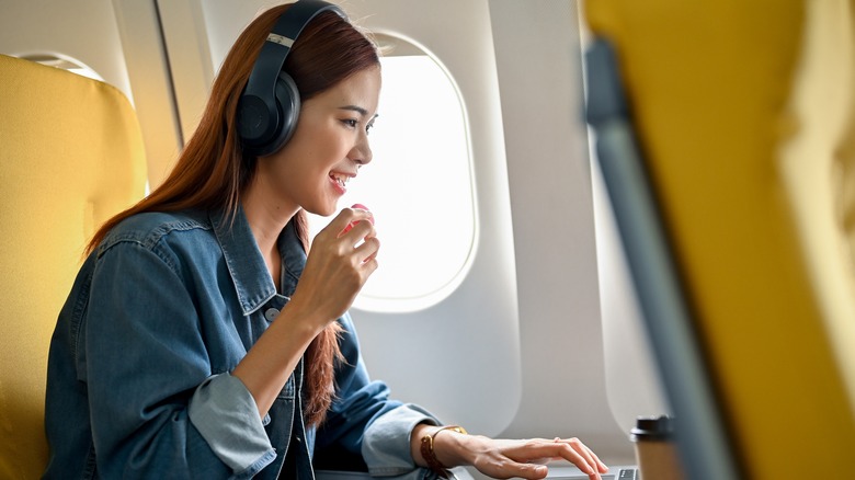 Woman on airplane with laptop